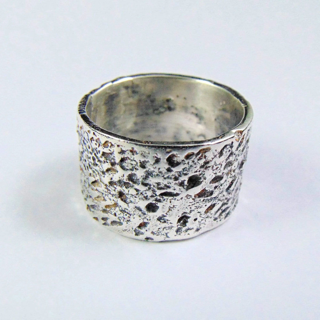 Srebrna, szeroka obrączka wykonana tradycyjnymi technikami jubilerskimi. Ręcznie fakturowana. Ponadczasowy design unisex